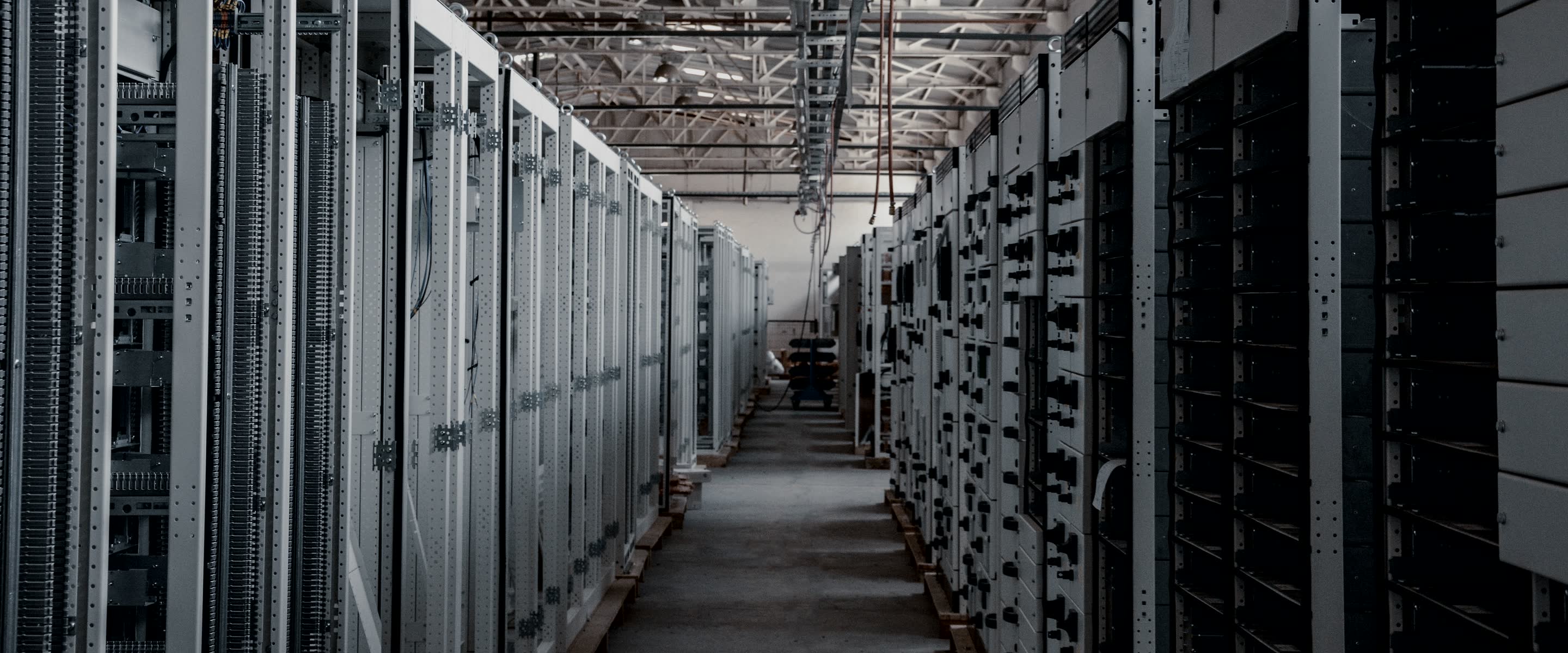 A lit aisle between cabinet rows in a production data hall