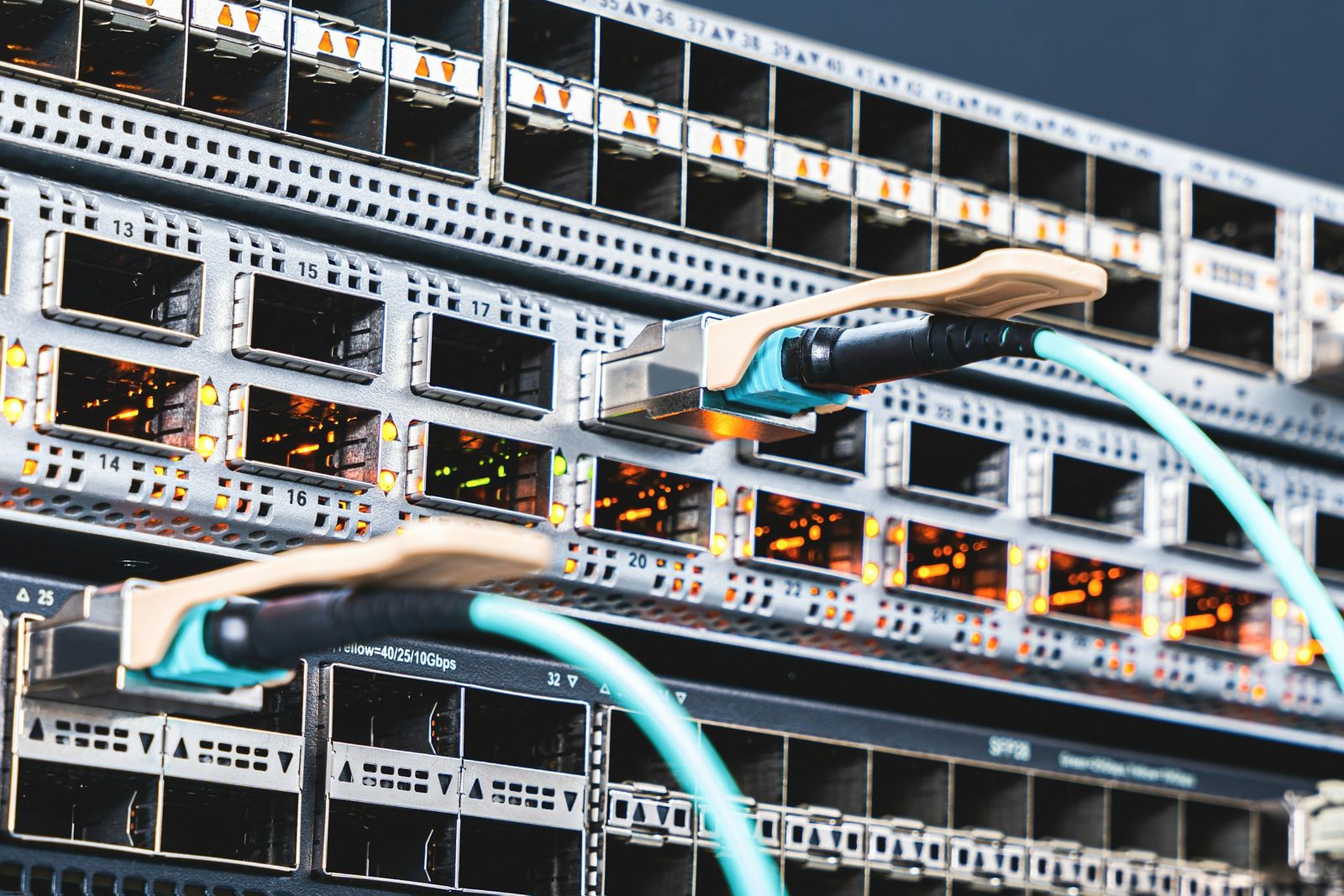 Teal patch cords traced into numbered ports across two switch line cards
