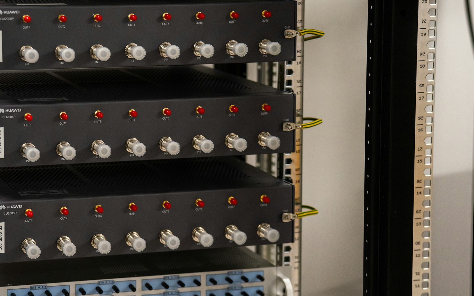Rack-mounted units with indicator lights and coaxial connectors, mounted against marked rack rails