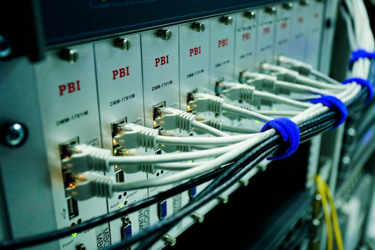 A labelled patch panel with terminated cabling, device faces and port markings visible